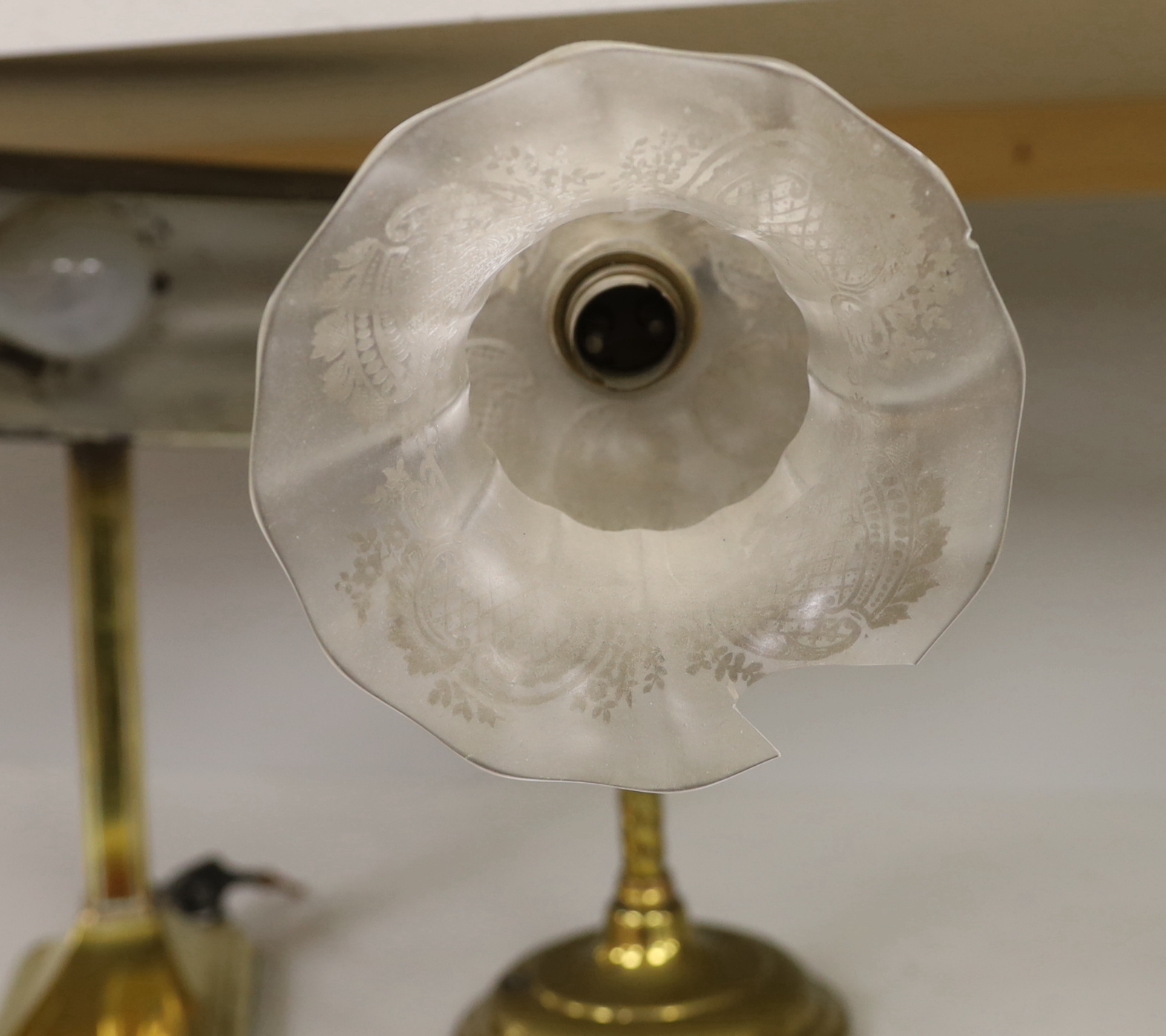 Two early 20th century brass reading lamps with Bakelite and etched opaque glass shades, the largest 54cm high